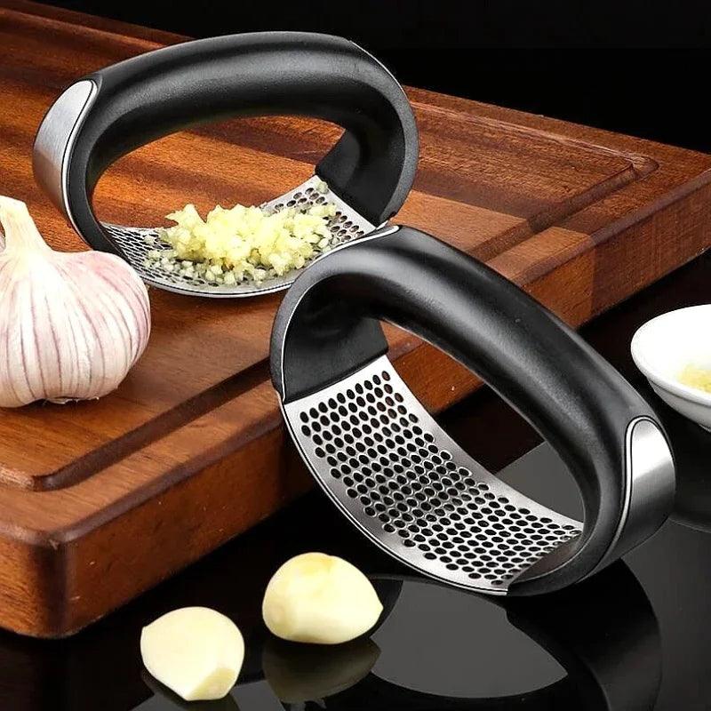 Stainless steel garlic press crusher and manual mincer for chopping garlic, fruits, and vegetables – durable kitchen tool and accessory.